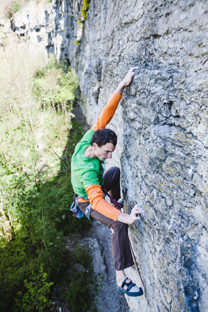 A man overcomes a difficult climbing route. A rock climber on a rock. Doing sports outdoors.の写真素材
