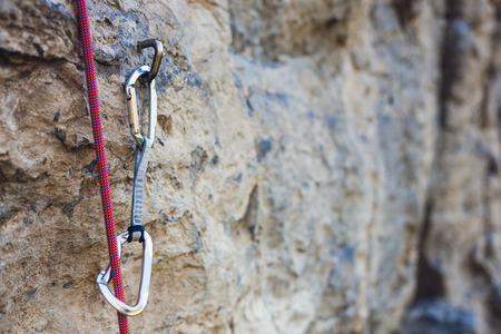 Quickdraw on the rock. Climbing equipment. Rope and carbine on the rock. Mountaineering equipment on the route.の写真素材