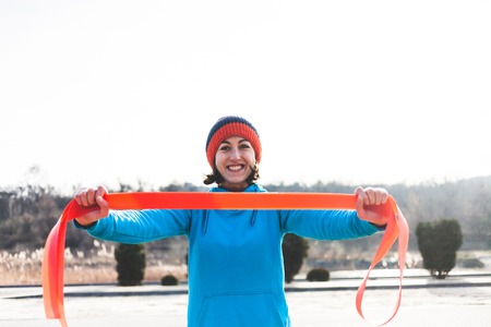 girl doing exercises in the street with a rubber band. exercise fitness on the street. a healthy lifestyle and a beautiful body.の写真素材