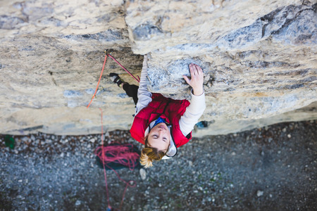 the girl climbs the rock. fitness in nature and rock climbing. the climber climbs up.の写真素材