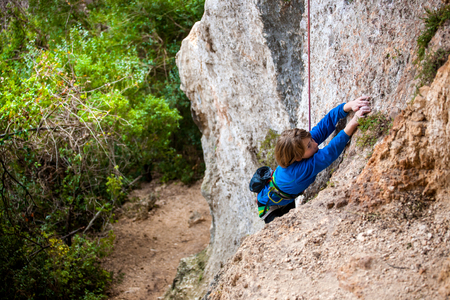 Boy climbing rock wallの写真素材