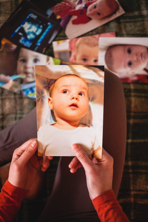 A woman looks at the pictures of a small child. Mom remembers her son's childhood. Moments of life...
