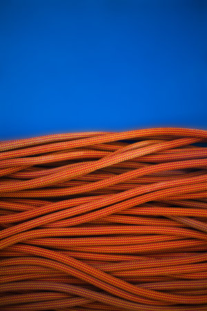 orange rope for climbing and climbing on a blue background. background image of the rope for active sports.の写真素材