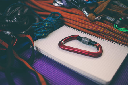 Notepad, rope and carbine. Equipment for rock climbing. Notebook and equipment for safety and...