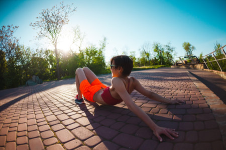 Yoga in the streets of the city. A girl is doing exercises at dawn. A woman is training in the park....
