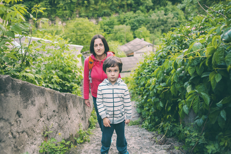A boy and his mother are walking in the old town. A woman travels with her son in historical places. The child is walking along the old paving stones. Tourist places of Ukraine.の写真素材