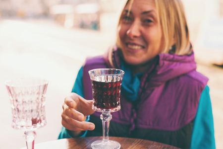 Woman holding a glass of red wine. Cherry brandy. Girl tasting alcoholic drink. Alcohol addiction.の写真素材