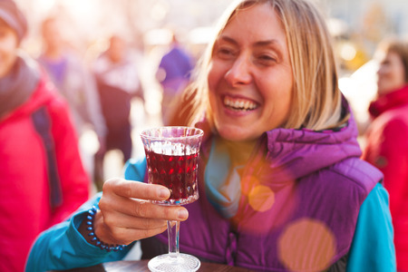 Woman holding a glass of red wine. Cherry brandy. Girl tasting alcoholic drink. Alcohol addiction.の写真素材