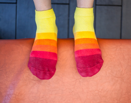 Striped women's socks. Women's feet in warm cotton socks. Cute clothes for the legs.の写真素材