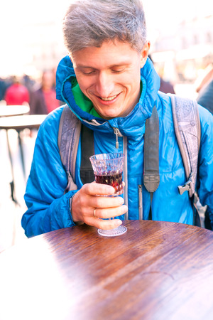 Man holding a glass of red wine. Cherry brandy. Man tasting alcoholic drink. Alcohol addiction.の写真素材