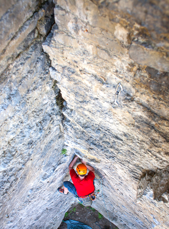Climber in a helmet climbs to the top of the mountain. Sport activities in nature.の写真素材