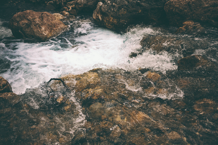 Mountain stream and large stones. Stormy creek in the forest close up. Large wet stones on the banks of the river. Little waterfall.の写真素材