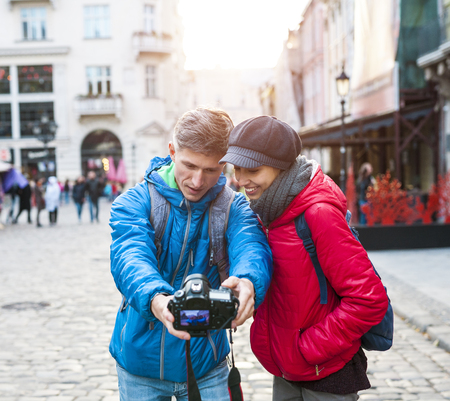 A man and woman take a selfie on camera. Lovers walk around the city. Couple on the old city street. Traveling in Europe.の写真素材