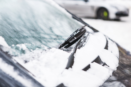 Snow covered dark car. Parked vehicle close up. The machine is covered with hoarfrost. Winter snowfall.の写真素材