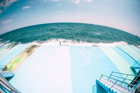 Pier on the waterfront. Sea waves break on the breakwater. Ocean landscape. Quay street resort town. Foam from sea water.の写真素材