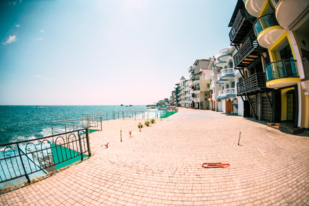 Street along the sea shore. Quay without people. Ocean coast. Buildings by the sea.の写真素材