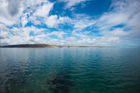 Sea coast of Croatia. Sea and sky with clouds. Calm water.