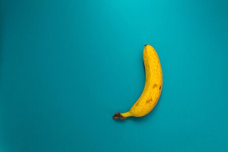 Banana on blue background. Ripe fruit. One banana on a turquoise background.の写真素材