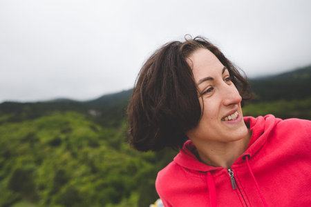 Portrait of a smiling woman. The girl is having fun in nature. Emotional brunette.