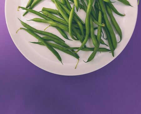 Asparagus beans on a white plate. A legume plant. Boiled beans. Vegetarian dish on a purple background.の写真素材