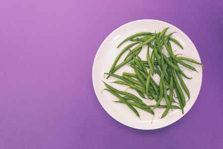 Asparagus beans on a white plate. A legume plant. Boiled beans. Vegetarian dish on a purple background.の写真素材