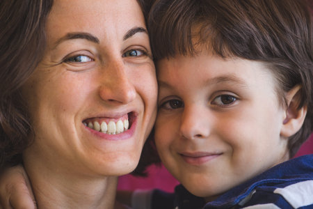 Cute boy kisses and hugs mom. Portrait of a woman with a child. A woman hugs her son.