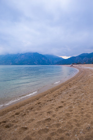 Sea on a cloudy day. Turkish beach in a rainy day. Storm clouds. Sandy beach on a background of high...