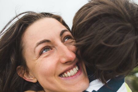 The boy hugs mom. Woman rests with her son in nature. The child kisses mom. Portrait of a mother and baby.の写真素材