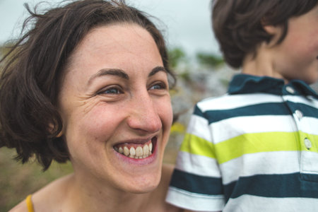 The boy hugs mom. Woman rests with her son in nature. The child kisses mom. Portrait of a mother and...