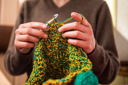 Woman crochets. Handwork. Crochet hook. Female hands closeup. Female hands hold the hook. Vintage carpet. Knitted plaid. Handmade. Home hobby.の写真素材