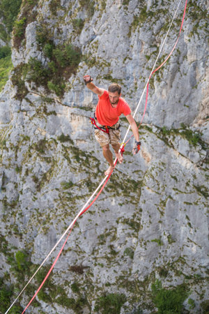 Highline in the mountains. A man goes on a stretched sling. Highline is on the line. A tightrope...