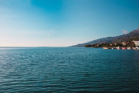 Mountains and the sea. Adriatic coast of Croatia. Town by the sea. Seaside city against the sky with clouds.の写真素材