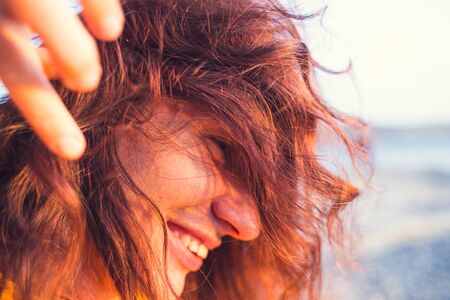Portrait of a long haired girl. Smiling brunette. Woman without makeup. Long curly hair. A woman is resting in nature.の写真素材