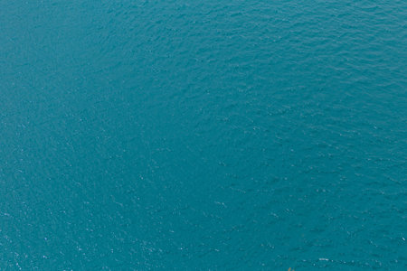 Background shot of aqua sea water surface. Water background with blue peaceful ripples for use as...