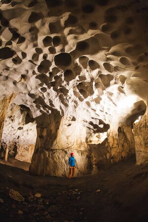 A man stands in a large cave. Tourist sightseeing. Sights of Turkey. Caver exploring the cave.の写真素材