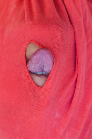 A hole in clothes. Red cloth. Female lips and tongue. Grimace. To make faces. Fool.