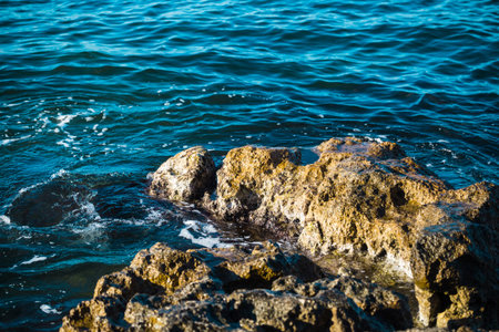 Ocean waves wash the stones. Rocky shore. Sea foam. Beautiful sea coast. Pure water. Water surface....