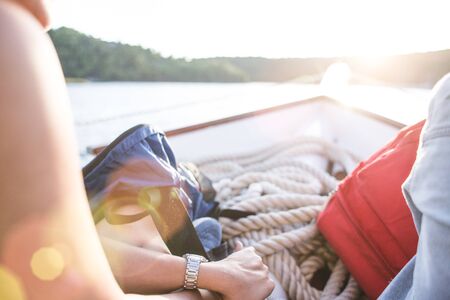 friends travel by boat. two girls with backpacks sailing on a boat on the river.の写真素材