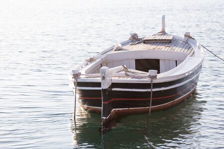 Wooden boat on the pier. Powerboat. Marine vehicle. Calm water.の写真素材