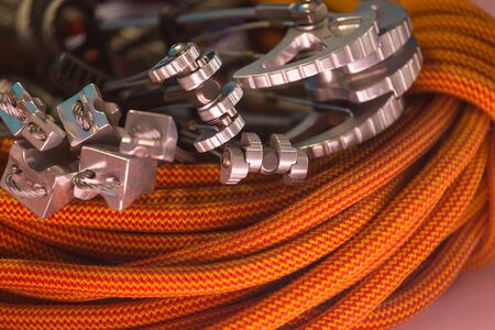 climbing equipment folded on an orange rope. modern equipment for climbing in the mountains. adventure on the rocks.の写真素材