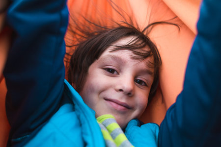 Cute boy is sitting in a hammock. Portrait of a brown-eyed child. The kid is riding in a hammock....