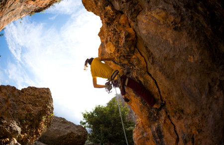 A strong rock climber is training on Turkish rocks, A woman climbs a climbing route, Extreme hobby,...