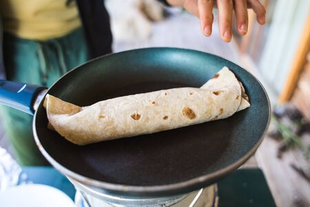 Cooking pita rolls stuffed with vegetables. Stuffing for tacos. Eastern cuisine. Pita bread in a pan.の写真素材