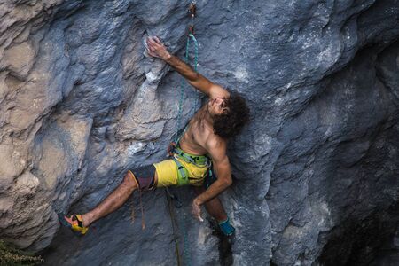 A strong man climbs a rock, Strong back muscles, Rock climbing in Turkey, Training endurance and strength, man in extreme sport, Rock climber is training in nature.の写真素材