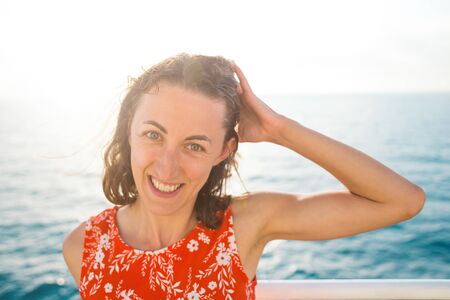 Portrait of a smiling woman on a background of the sea, a girl resting on the sea coast, emotional brunette.の写真素材