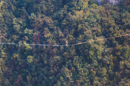 Highline in the mountains. A man goes on a stretched sling. Highline is on the line. A tightrope...