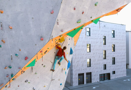 A man climbs a climbing wall, a climber is training on artificial terrain, rock climbing in the...