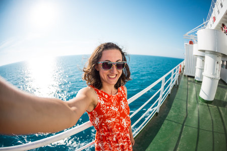 A woman is sailing on a cruise ship, a girl is standing near the fence on a ship against the sea and...