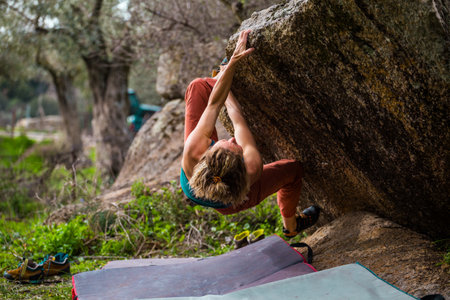 beautiful sports girl rock climber climbs the overhanging stone. bouldering in nature. sport climbing. fitness in nature.の写真素材
