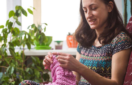 woman knits. home woolen clothes. in her free time, the girl is engaged in a hobby.の写真素材